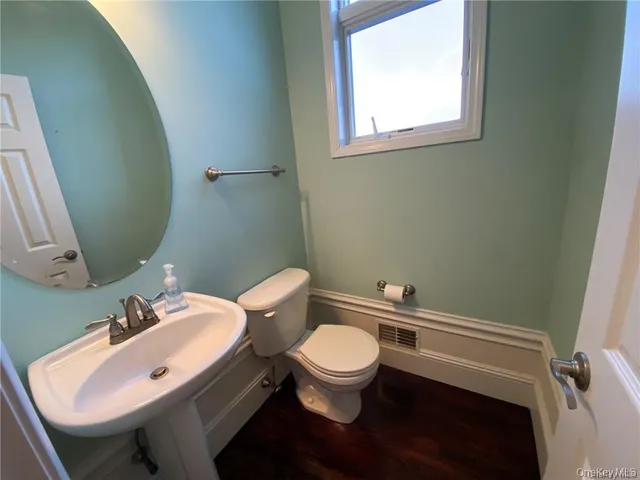 a bathroom with a toilet a sink and a mirror