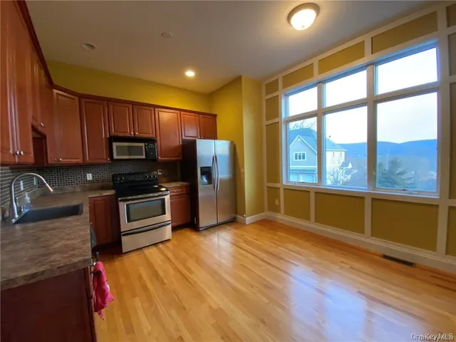 a kitchen with stainless steel appliances a stove top oven a sink and a refrigerator