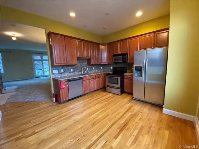 a kitchen with stainless steel appliances granite countertop a refrigerator microwave and sink