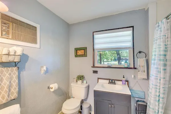 a bathroom with a toilet a sink and a window
