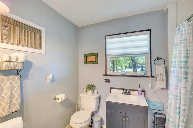 a bathroom with a toilet a sink and a window