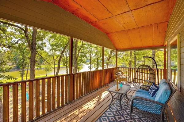 a balcony with wooden floor and outdoor seating