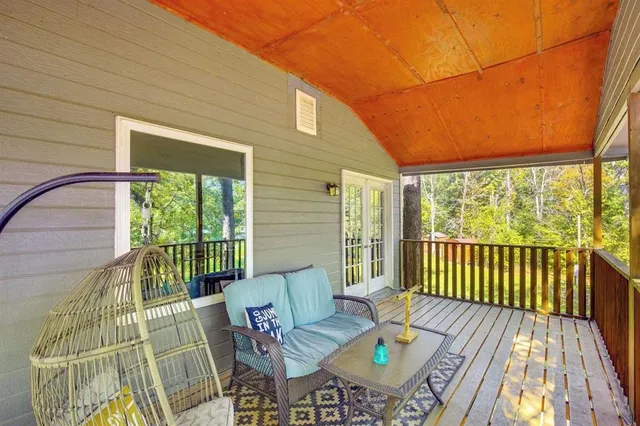 a balcony with wooden floor table and chairs