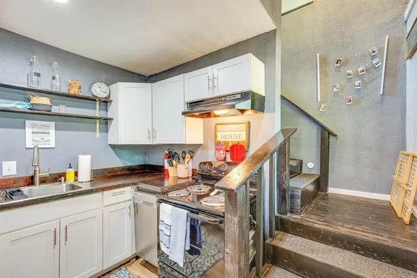 a kitchen with stainless steel appliances granite countertop a sink a stove and cabinets