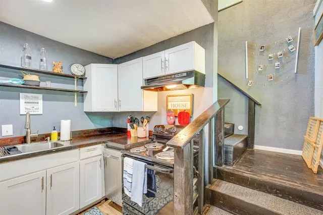 a kitchen with stainless steel appliances granite countertop a sink a stove and cabinets