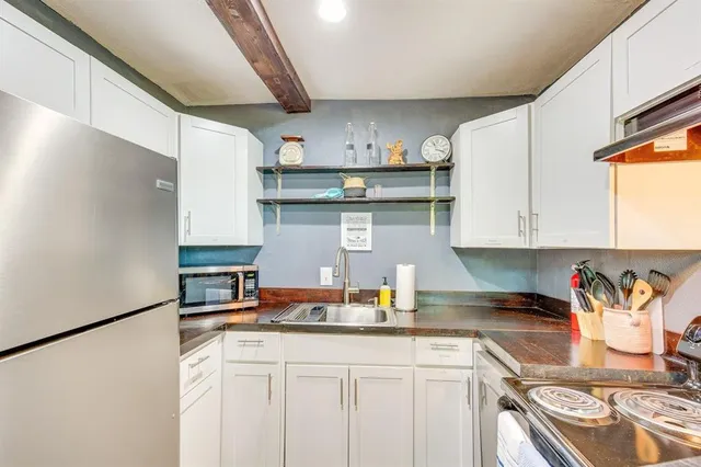 a kitchen with stainless steel appliances granite countertop a sink a stove and a refrigerator