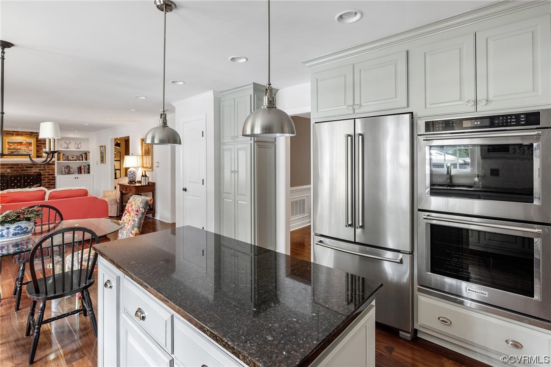 2921 Barrow Place Midlothian, VA 23113 - Photo 9 of 41 a kitchen with stainless steel appliances granite countertop a kitchen island a stove a refrigerator a dining table and chairs with wooden floor