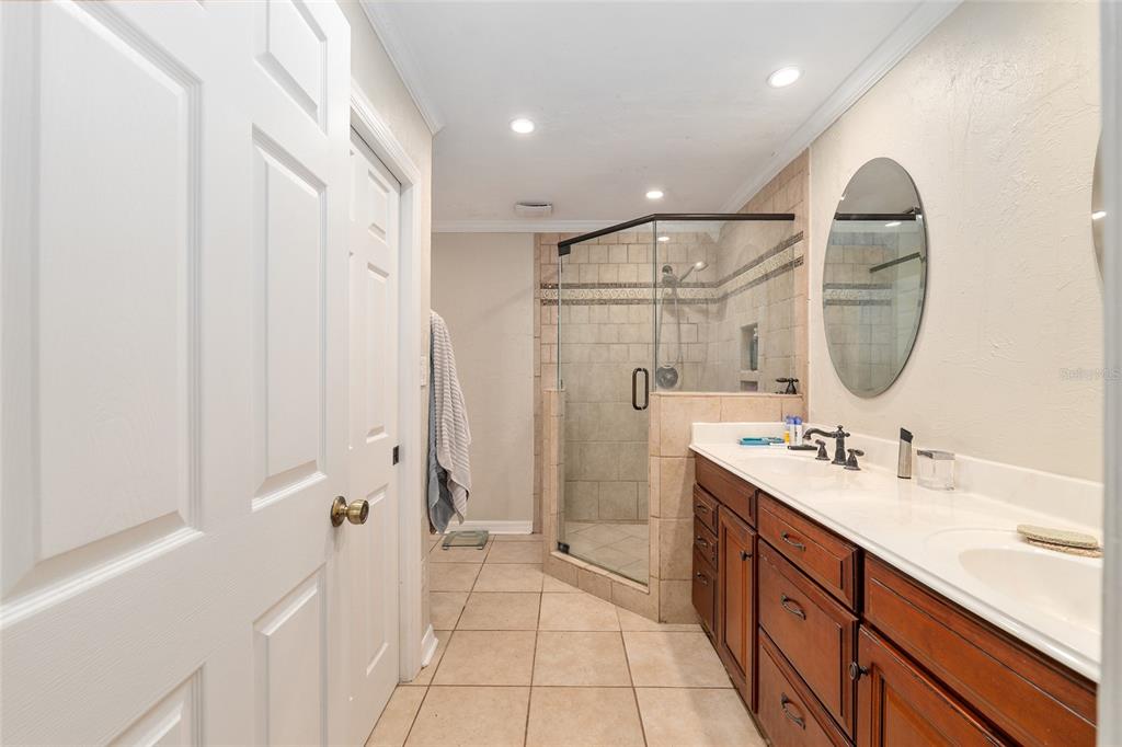 9917 Southwest 77 Court Gainesville, FL 32608 - Photo 18 of 28 a spacious bathroom with a double vanity sink a mirror and a shower