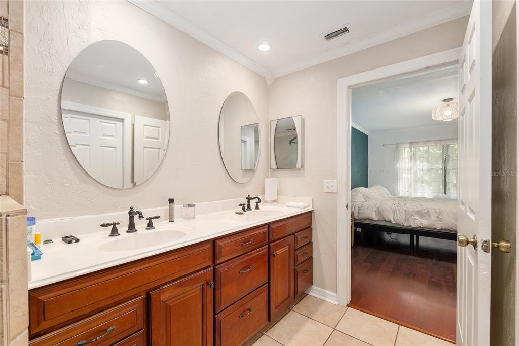 9917 Southwest 77 Court Gainesville, FL 32608 - Photo 19 of 28 a en suite bathroom with double vanity and a mirror