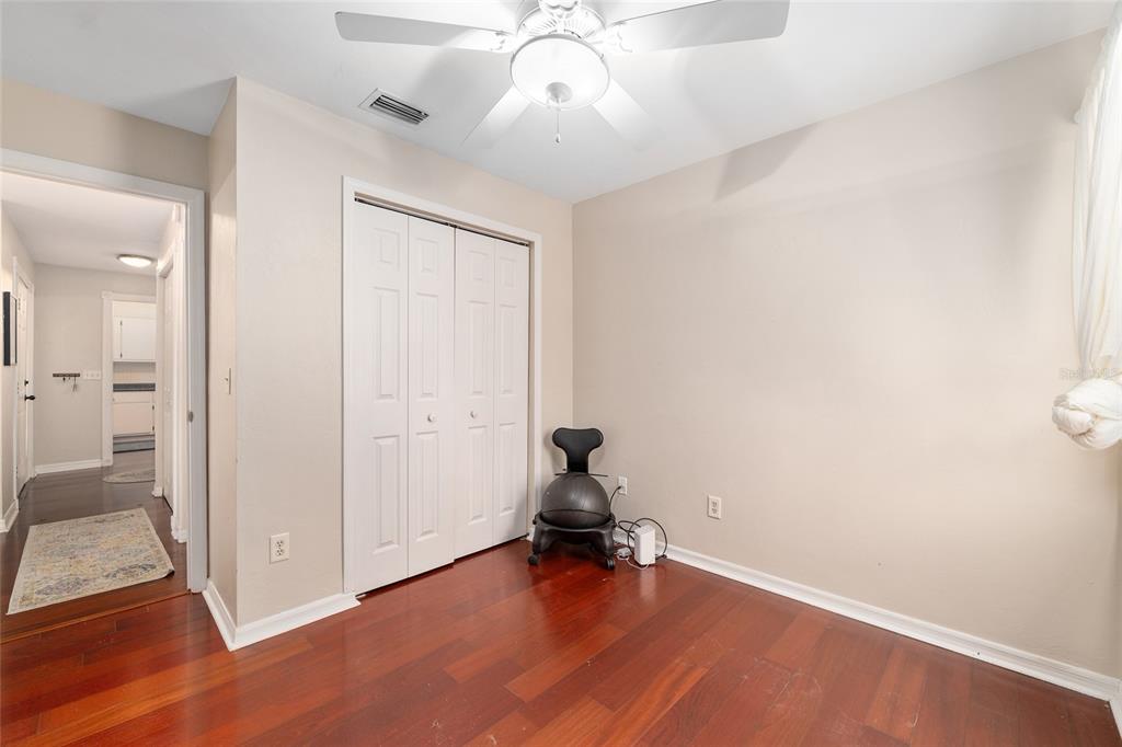 9917 Southwest 77 Court Gainesville, FL 32608 - Photo 21 of 28 an empty room with wooden floor and windows