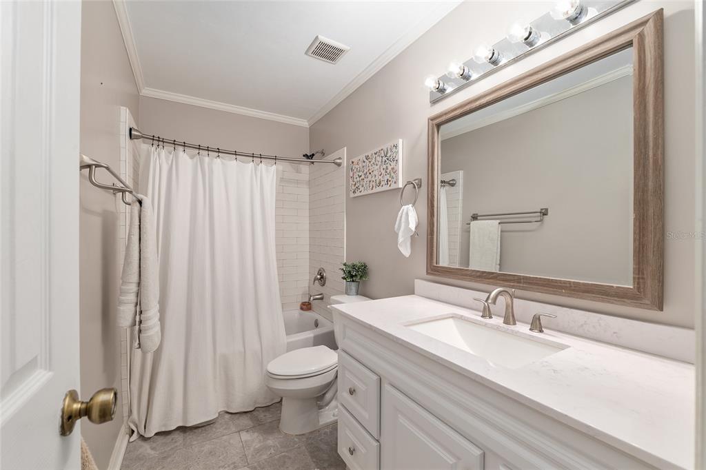 9917 Southwest 77 Court Gainesville, FL 32608 - Photo 22 of 28 a bathroom with a granite countertop sink a toilet and a mirror