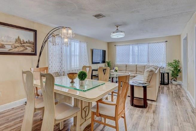1105 West 34th Street Riviera Beach, FL 33404 - Photo 13 of 15 a view of a dining room with furniture and wooden floor