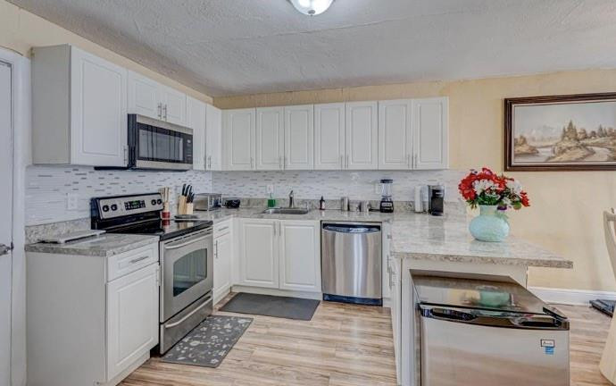 1105 West 34th Street Riviera Beach, FL 33404 - Photo 2 of 15 a kitchen with granite countertop cabinets stainless steel appliances and wooden floor