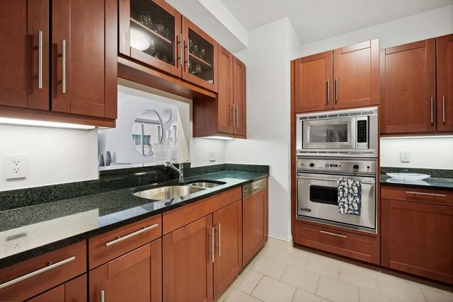 a kitchen with granite countertop wood cabinets and a sink