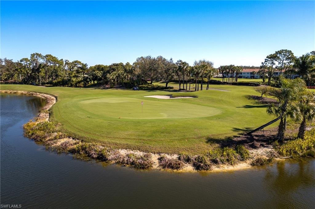 9209 Spring Run Boulevard, Unit 2003 Estero, FL 34135 - Photo 26 of 32 a view of a lake with lawn chairs