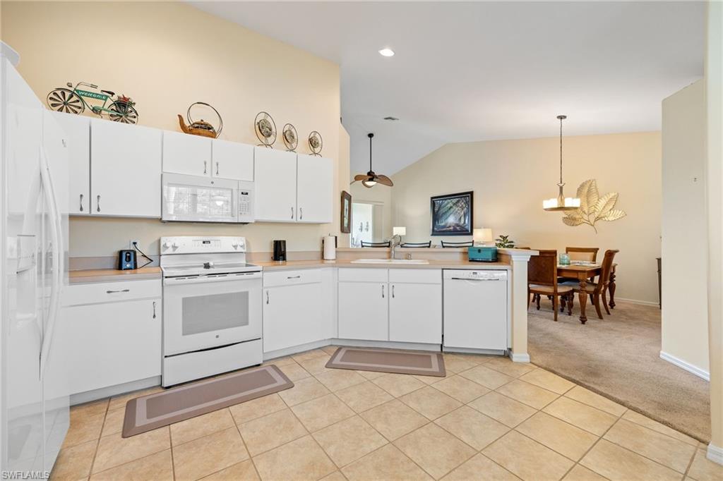 9209 Spring Run Boulevard, Unit 2003 Estero, FL 34135 - Photo 5 of 32 a kitchen with cabinets appliances and a dining table