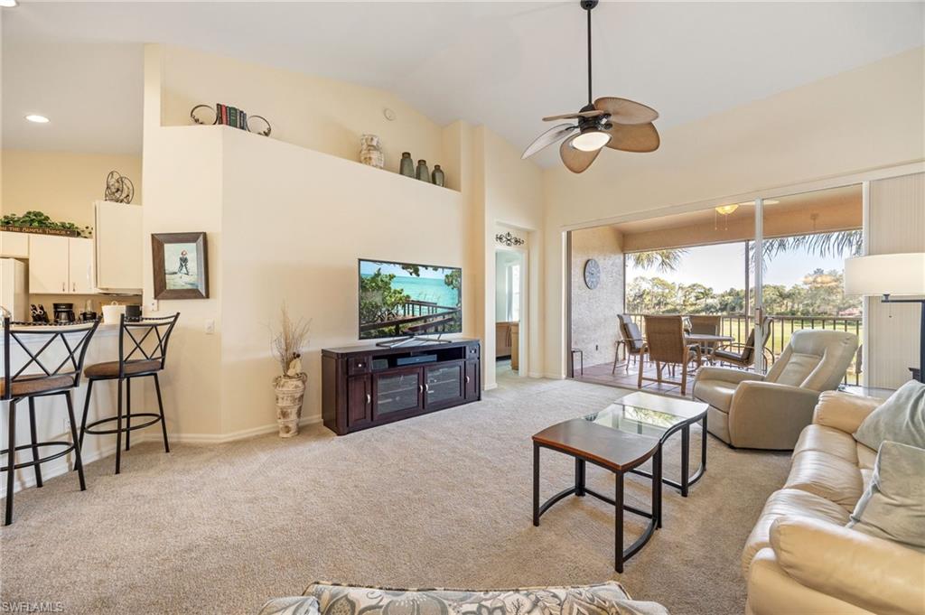 9209 Spring Run Boulevard, Unit 2003 Estero, FL 34135 - Photo 10 of 32 a living room with furniture a floor to ceiling window and a flat screen tv