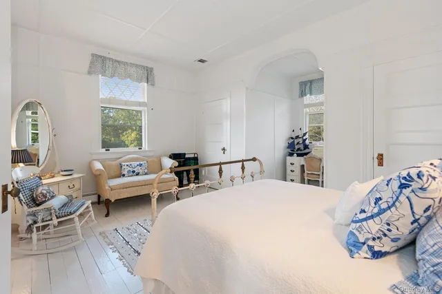 a bedroom with a bed and large windows