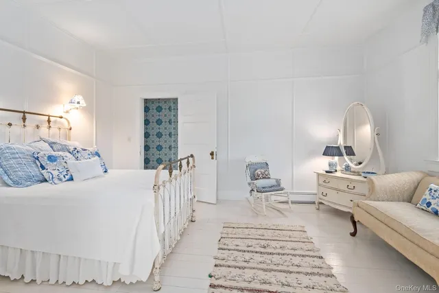 a bedroom with a bed and a painting on the wall