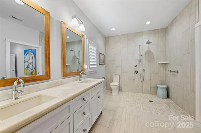 a spacious bathroom with double sink and a large mirror