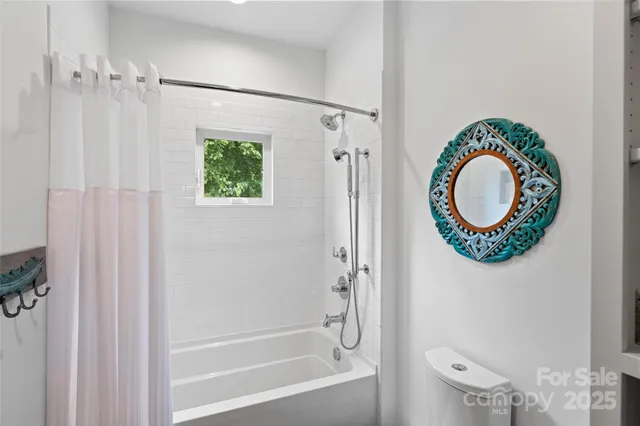 a bathroom with a shower a mirror and a shower