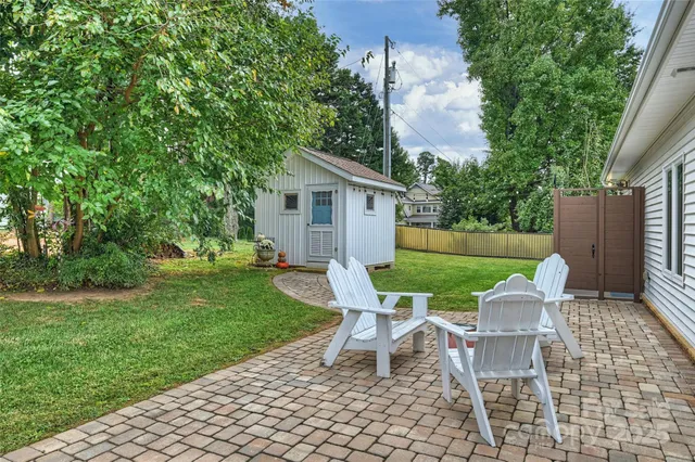 a view of a chair and table in backyard of the house
