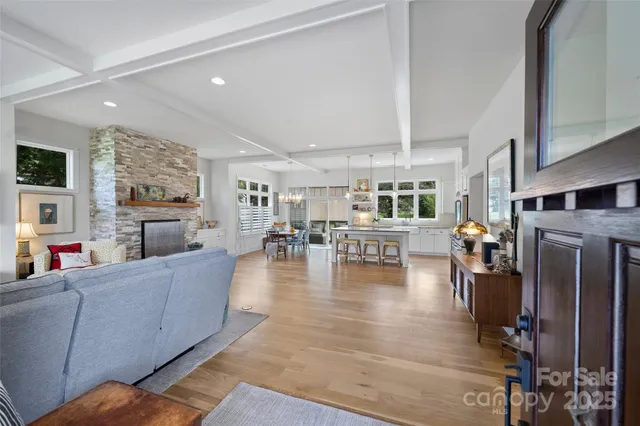 a living room with fireplace furniture and a large window