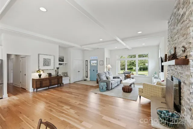 a living room with fireplace furniture and a large window