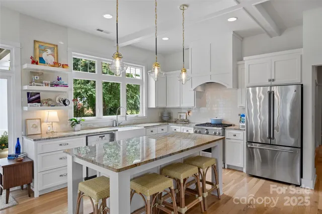 a kitchen with granite countertop stainless steel appliances a refrigerator a sink and a stove