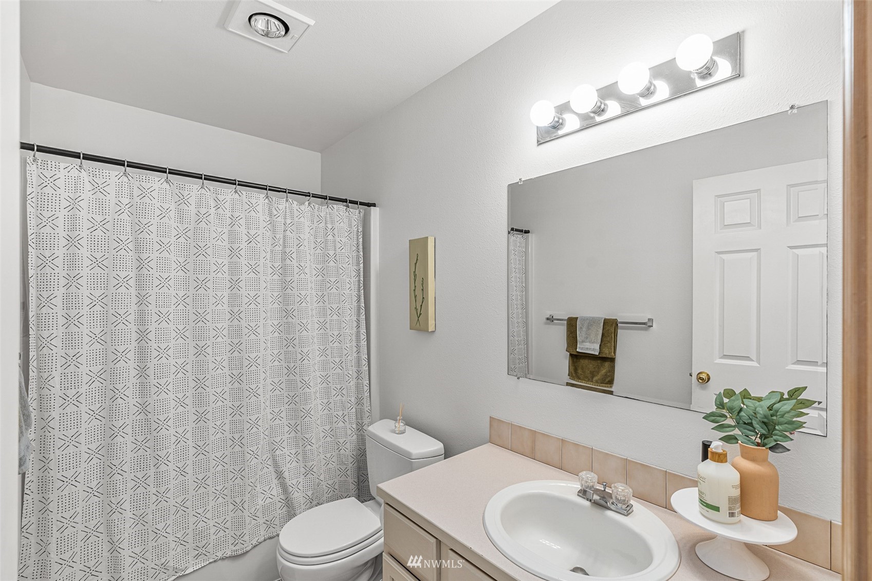 19329 Winesap Road Bothell, WA 98012 - Photo 12 of 32 a bathroom with a sink a toilet and shower curtain