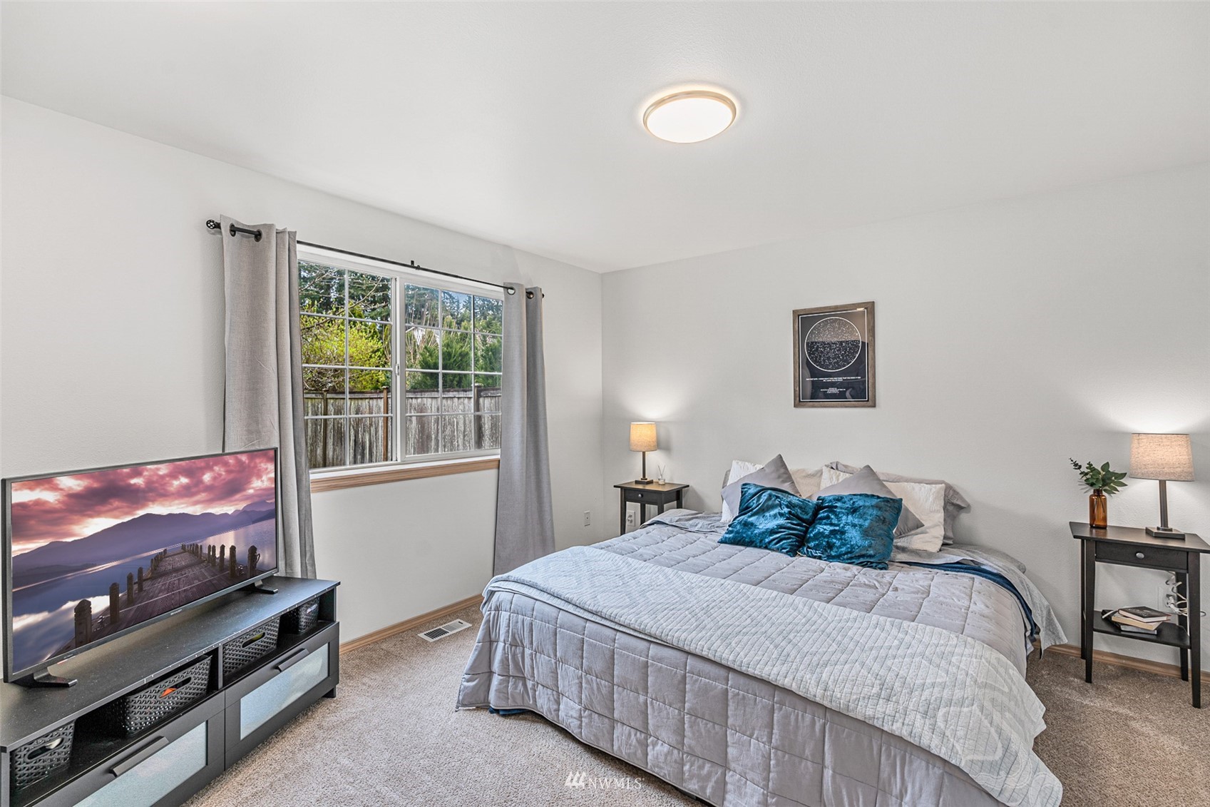 19329 Winesap Road Bothell, WA 98012 - Photo 16 of 32 a bedroom with a bed and a flat screen tv