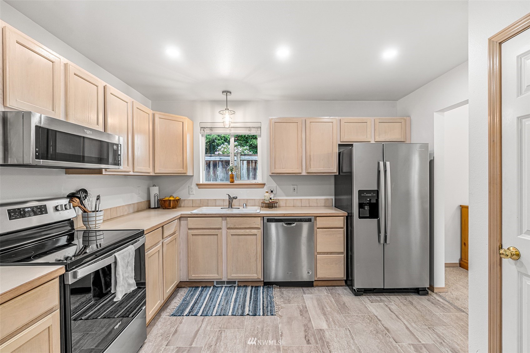 19329 Winesap Road Bothell, WA 98012 - Photo 6 of 32 a kitchen with a sink a microwave a refrigerator and cabinets