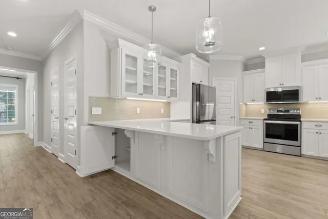 a kitchen with stainless steel appliances granite countertop a refrigerator a sink and a stove with wooden floor