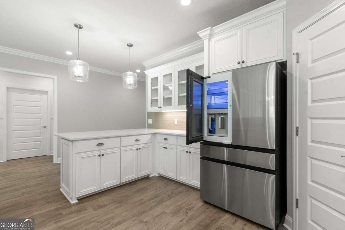 107 Amanda Trace Kingsland, GA 31548 - Photo 16 of 94 a kitchen with stainless steel appliances granite countertop a refrigerator a sink and white cabinets