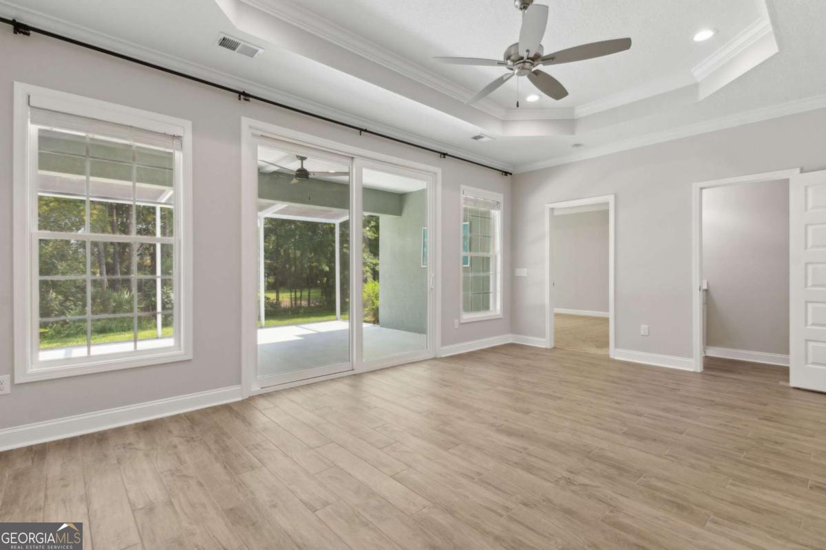 107 Amanda Trace Kingsland, GA 31548 - Photo 21 of 94 a view of an empty room with a window and wooden floor