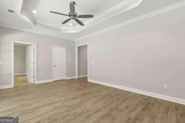 an empty room with a window and a ceiling fan