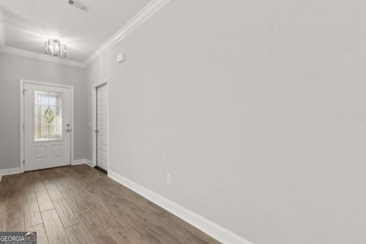 107 Amanda Trace Kingsland, GA 31548 - Photo 6 of 94 a view of an empty room with wooden floor and a window