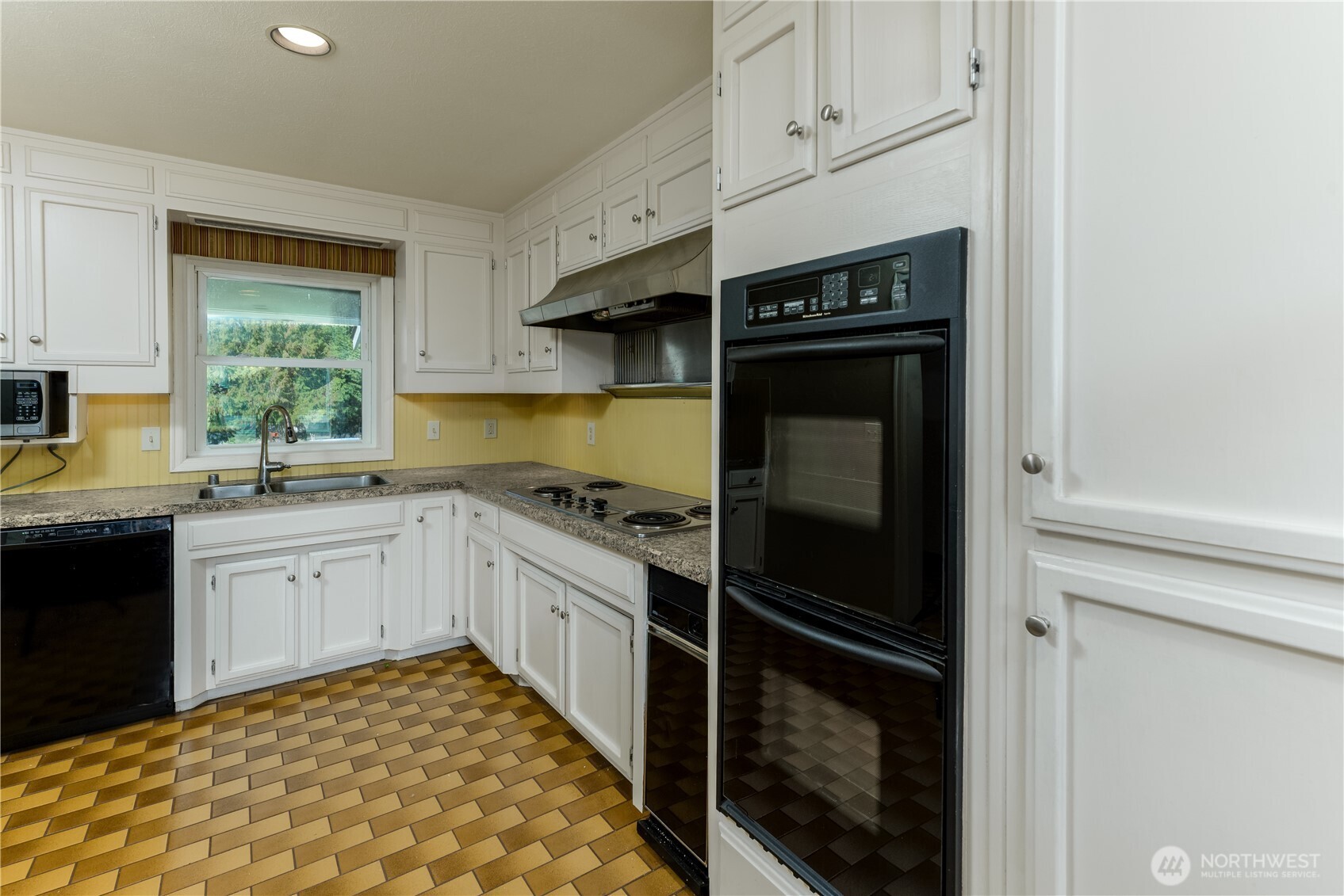 103 Turnagain Place Sequim, WA 98382 - Photo 14 of 40 a kitchen with granite countertop white cabinets and white appliances