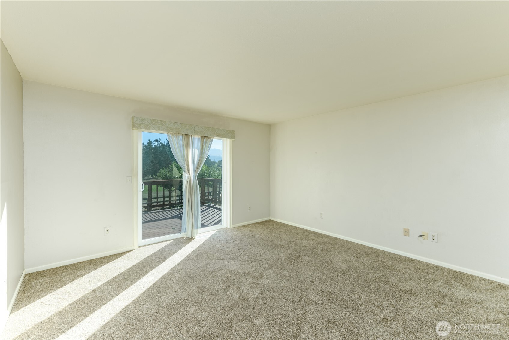 103 Turnagain Place Sequim, WA 98382 - Photo 24 of 40 an empty room with floor to ceiling window and an outdoor view