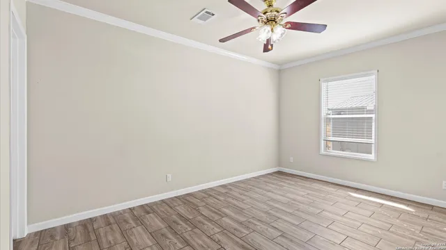 an empty room with a window and a fan