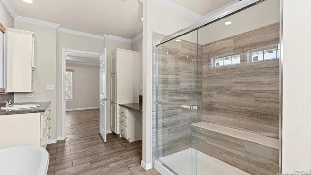 a bathroom with a glass shower door and a sink