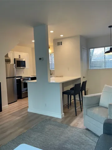 a view of kitchen with furniture and stainless steel appliances