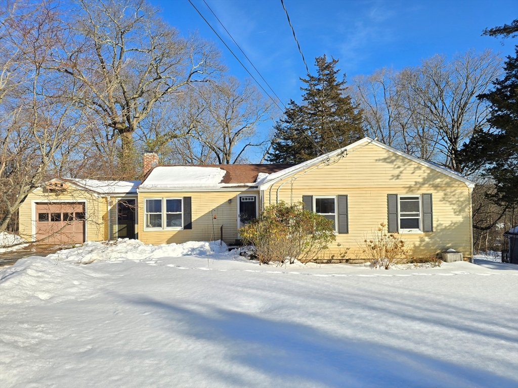 a front view of a house with a yard covered in snow