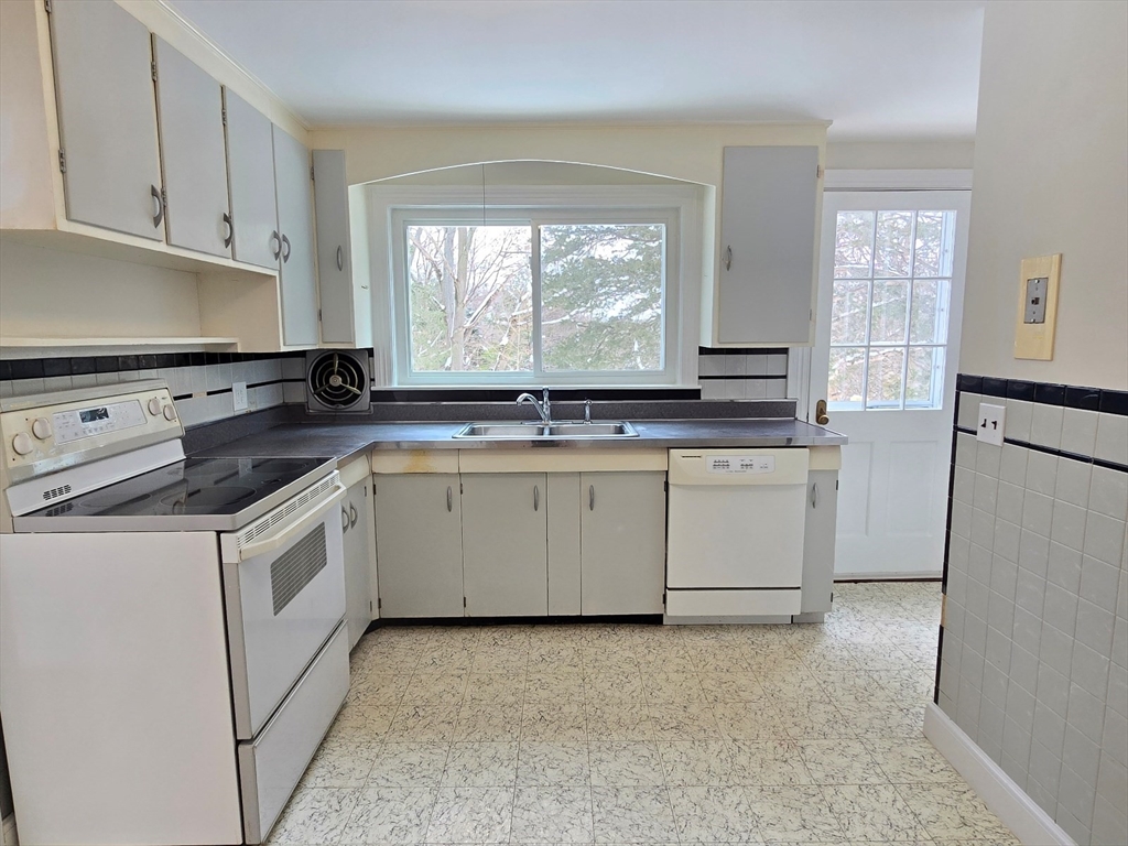 37 Riverview Drive Ashland, MA 01721 - Photo 14 of 30 a kitchen with granite countertop white cabinets and white appliances