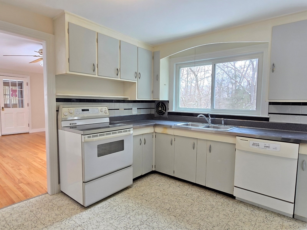 37 Riverview Drive Ashland, MA 01721 - Photo 15 of 30 a kitchen with granite countertop white cabinets window and stainless steel appliances