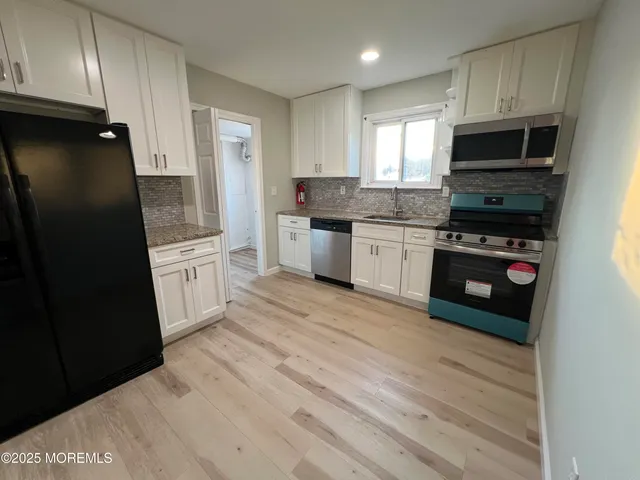 a kitchen with a refrigerator stove top oven and sink