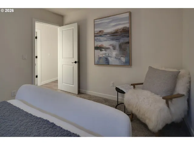 a bedroom with a bed and a painting on the wall