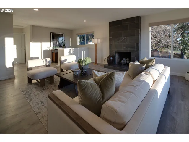 a living room with furniture fireplace and a large window