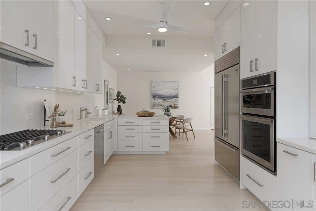 9660 Claiborne Square La Jolla, CA 92037 - Photo 11 of 23 a kitchen with white cabinets and appliances