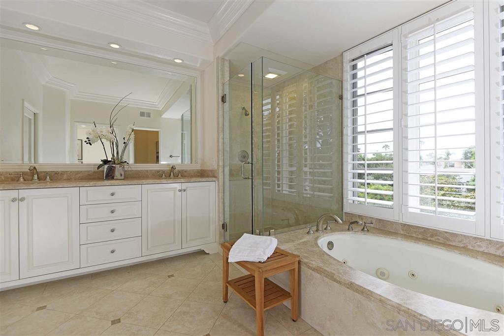 9660 Claiborne Square La Jolla, CA 92037 - Photo 17 of 23 a bathroom with a bathtub shower sink double vanity and mirror